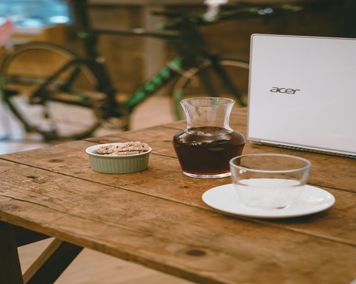 A glass of water next to a laptop on a wooden desk